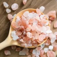 Upclose view of pink himalayan sea salt in a wodden spoon.